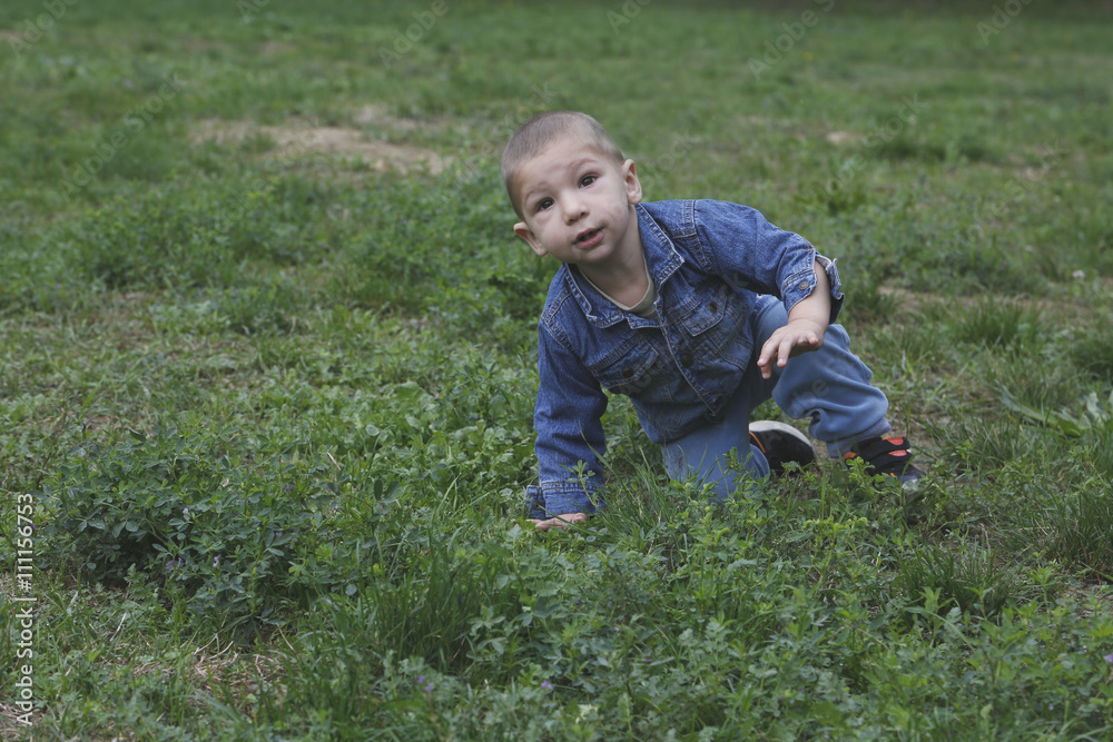 Small child is risign with one hand from the grass Small child is risign with one hand from the grass