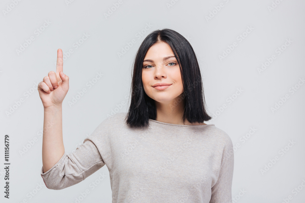 Portrait of a happy pretty girl pointing finger up Portrait of a happy pretty girl pointing finger up
