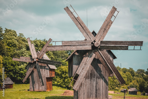 Very old wooden windmill on a grass field