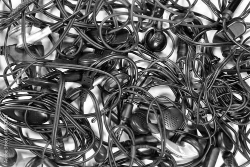 Tangled mess of headphones cables and earpieces. Audio connectors and jacks photo