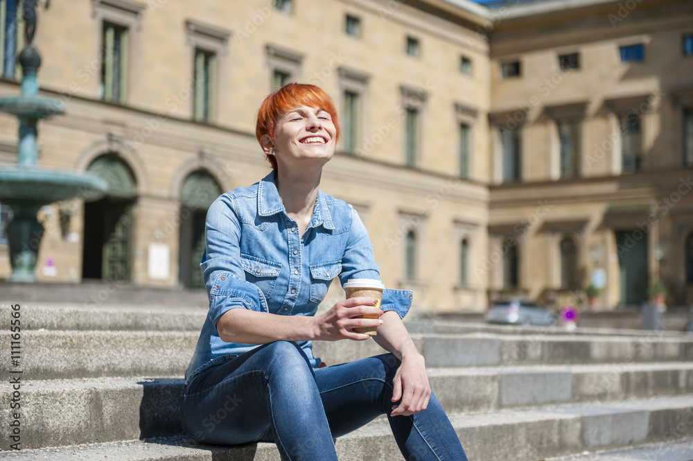 Young woman relaxing on stairs with coffee to go Young woman relaxing on stairs with coffee to go