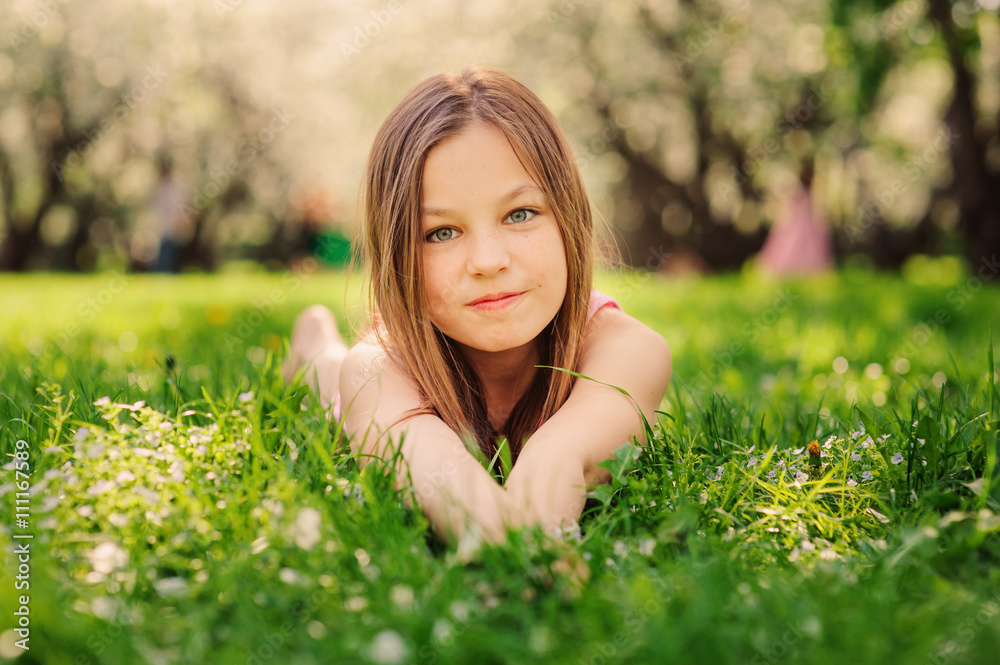 summer outdoor close up portrait of beautiful happy kid girl lying on the grass in park summer outdoor close up portrait of beautiful happy kid girl lying on the grass in park