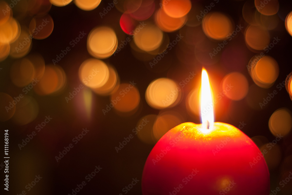 Red candle burning with lights behind Red candle burning with lights behind