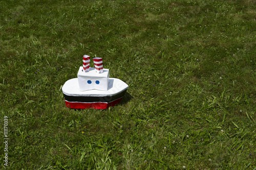 Boat made from paper on green grass lawn