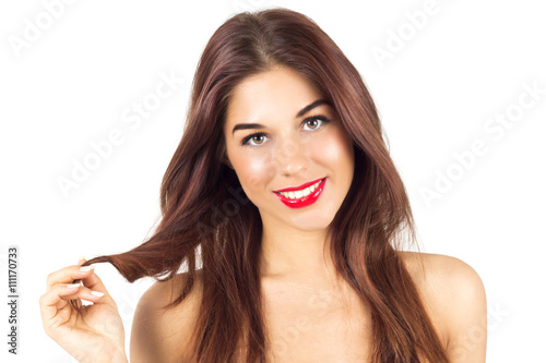 Sexy smiling tanned woman with red lips. Woman with make up. Tanned woman playing with her hair.