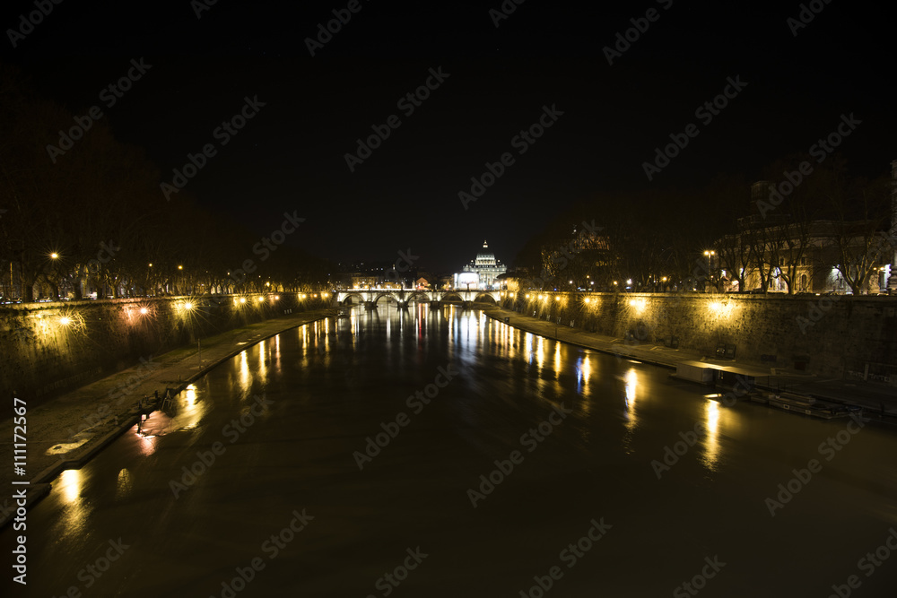 from a bridge over the Tiber river you can see the dome of St. Peter and bridge Vittorio Emanuele II