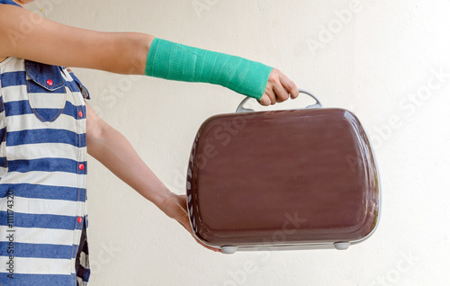 Injured woman with green cast on hand and arm, Travel insurance