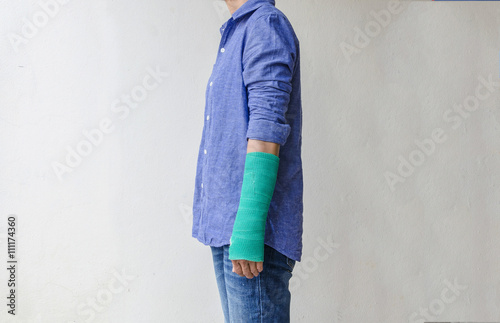 Injured woman with green cast on hand and arm, Travel insurance