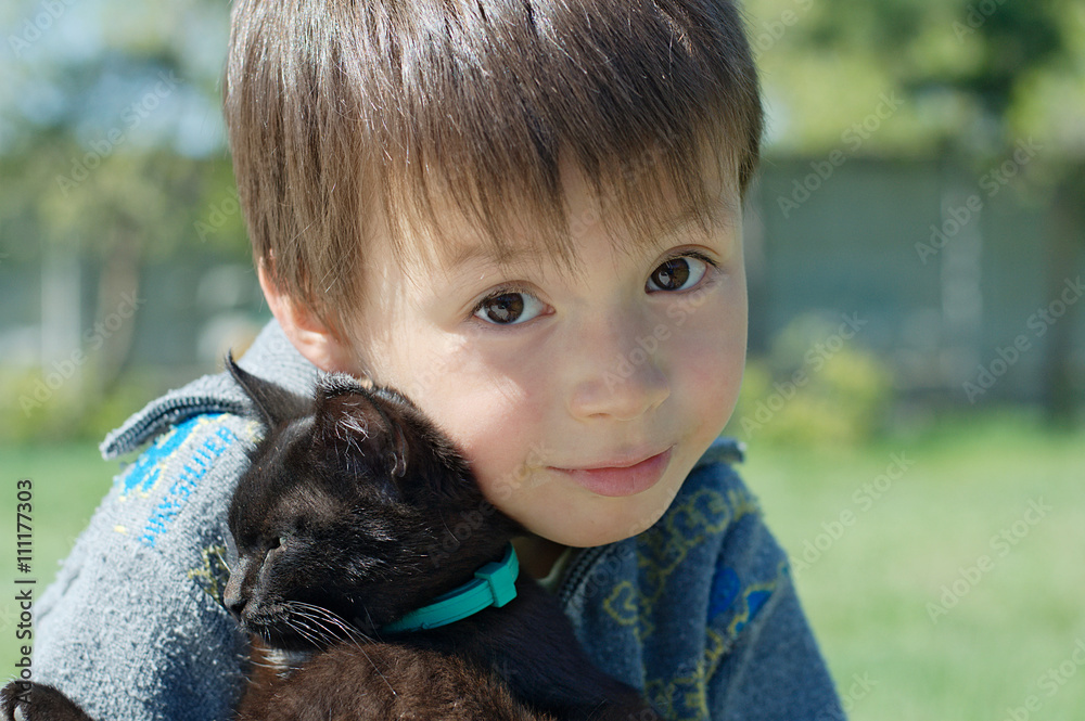Boy hugging black kitten Boy hugging black kitten