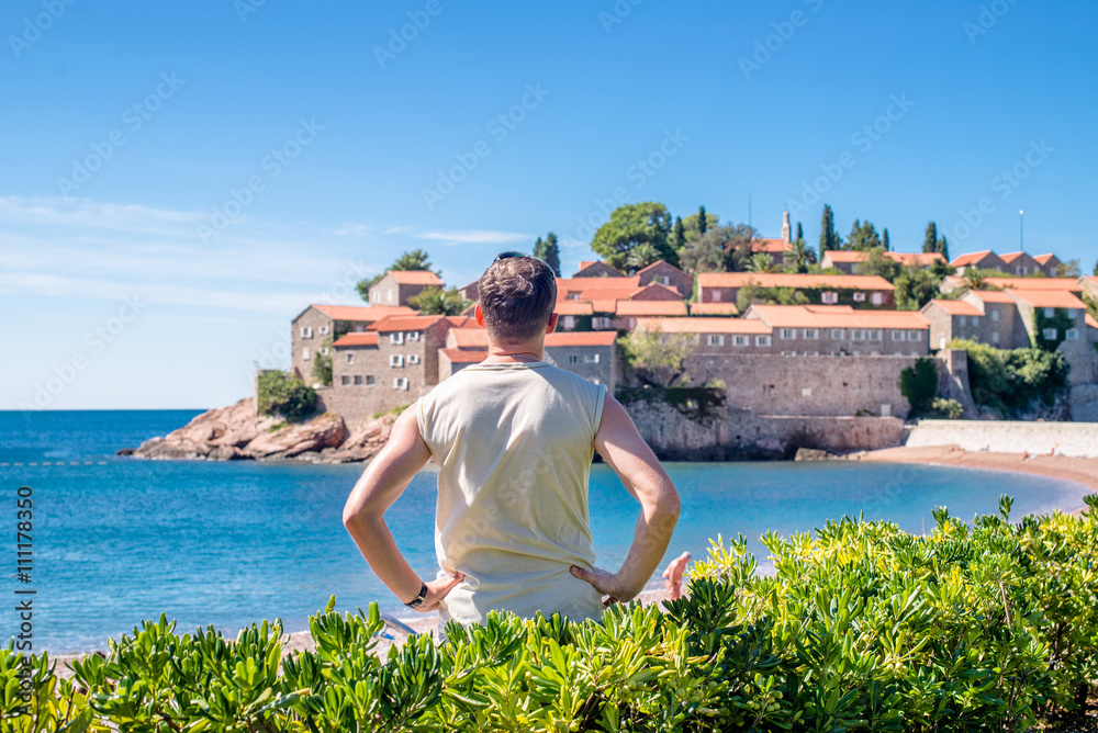 man looking over the bay near the island of Sveti Stefan