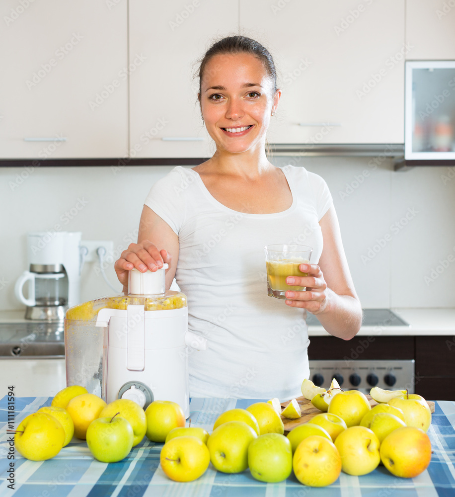 Girl making juice from apples