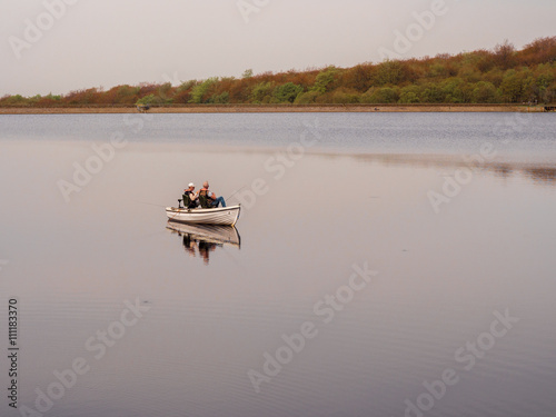 Tockholes, Lancashire, UK. May 6th 2016. Fishermen enjoying some quiet time in a boat on Roddlesworth Reservoir, Tockholes, Lancashire, UK photo