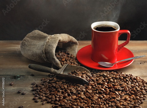 Coffee cup and coffee beans on wooden table