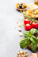 Italian food background with vine tomatoes, basil, spaghetti, olives, parmesan, olive oil, garlic