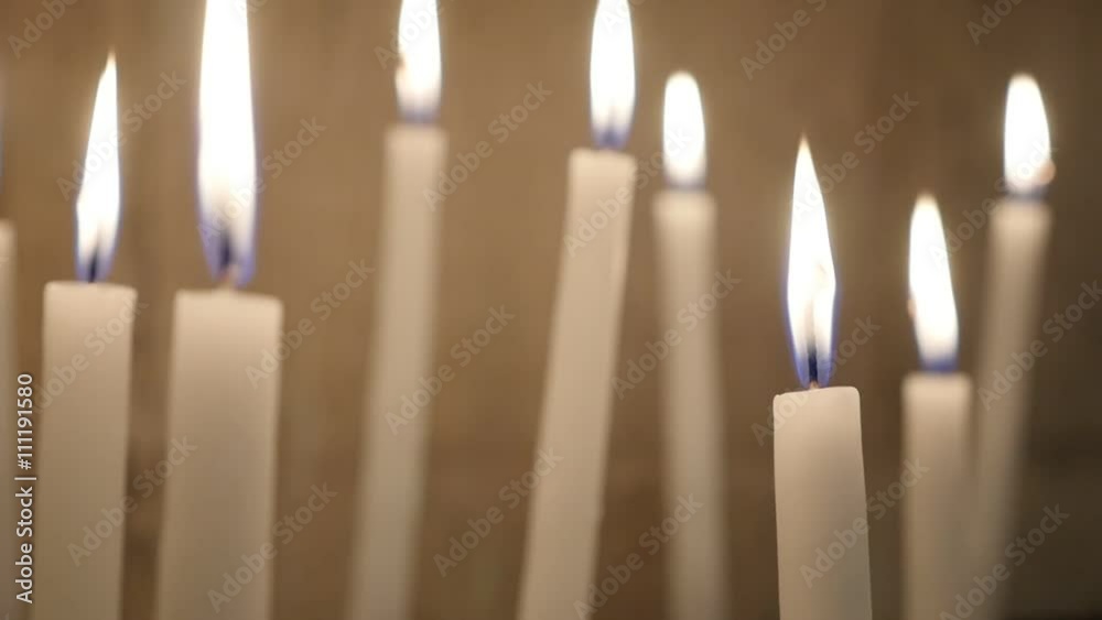 White votive candles burning slowly in the church in act oft Christian