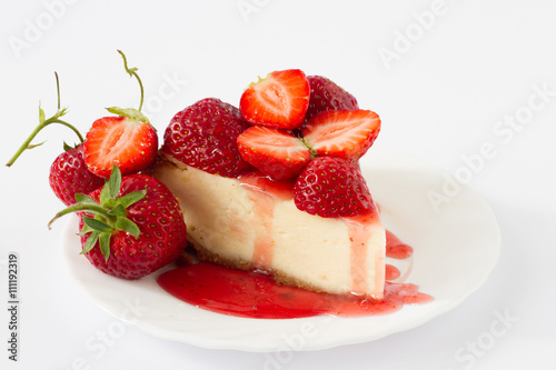 Slice strawberry cheesecake with fresh berries on white plate