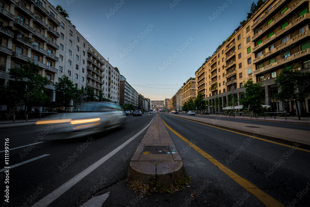 Fototapeta premium Panorama urbano cittadino con strada, segnaletica e palazzi a Milano