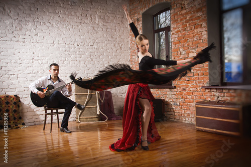 Young woman dancing flamenco and a man playing the guitar