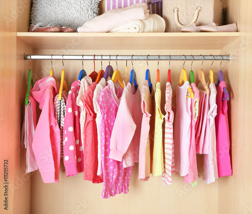 Girl's clothes on hangers in the wardrobe