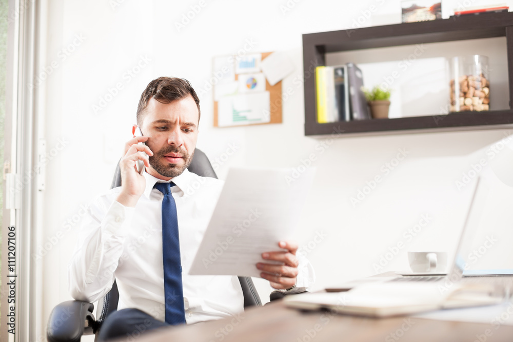 Lawyer taking an important phone call and reviewing a contract