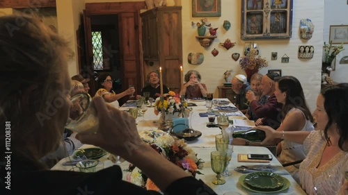 A large group of friends and family cheer with sparkling wine