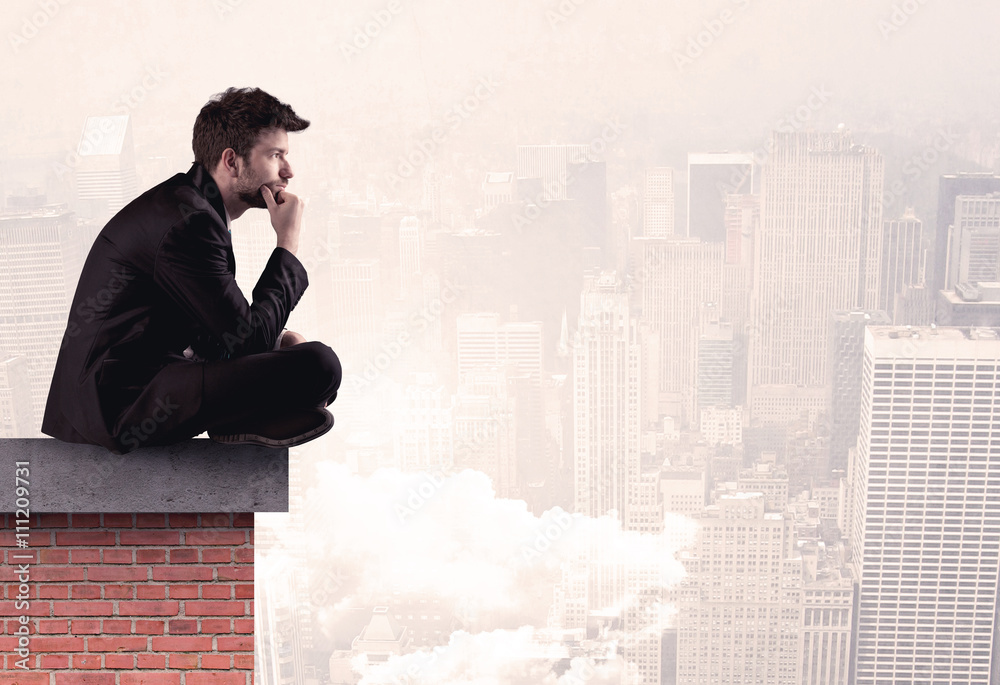 Office worker sitting on rooftop in city Office worker sitting on rooftop in city