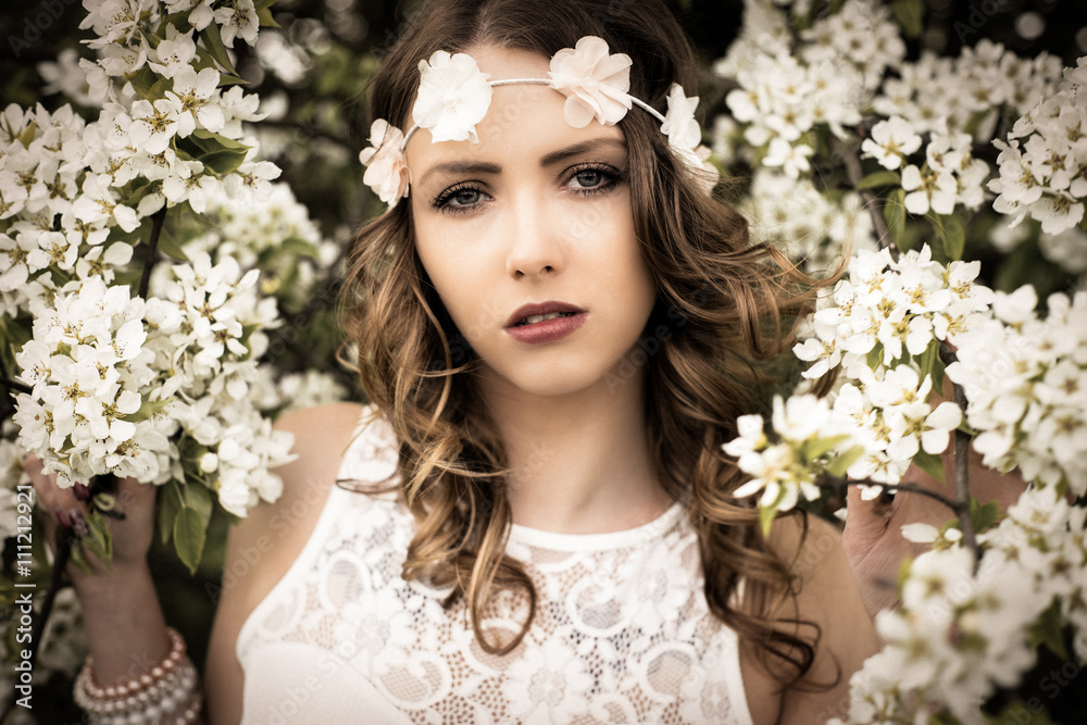 Spring / pretty woman with flower hair band in front of a blossoming apple tree Spring / pretty woman with flower hair band in front of a blossoming apple tree