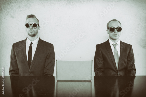 Two vintage businessman sitting at office desk photo