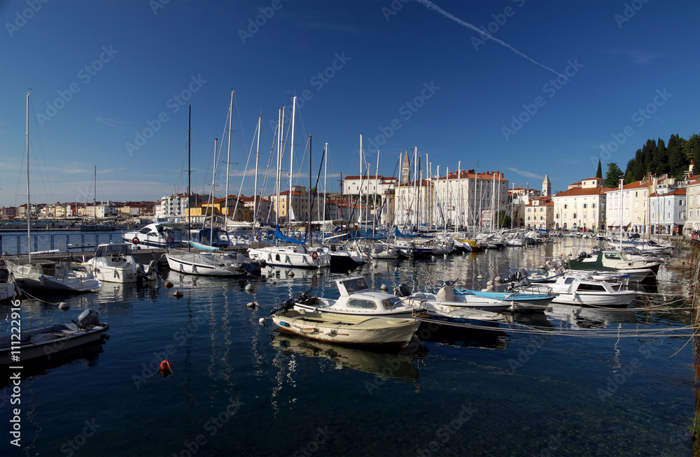 PIRAN, SLOVENIA - APRIL 16, 2016: Motorboats and yachts moored in Marina of coastal town. With narrow streets and compact houses Piran is a town in southwestern Slovenia on the Adriatic Sea