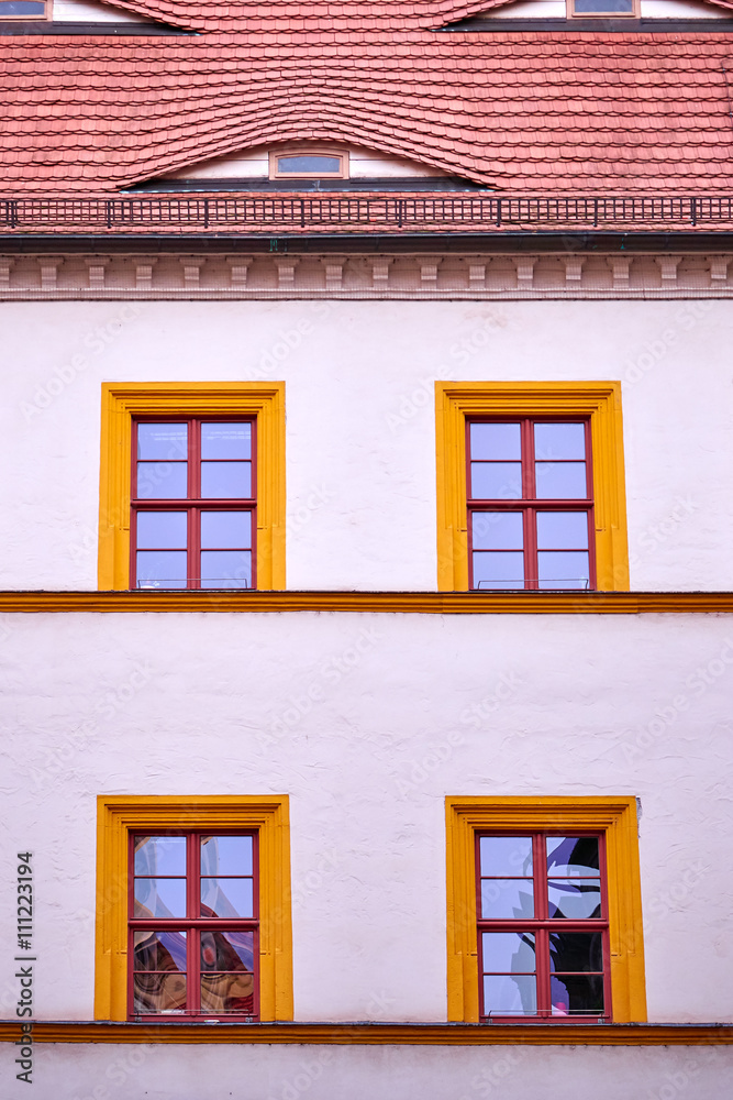 vintage building facade with four orange framed windows