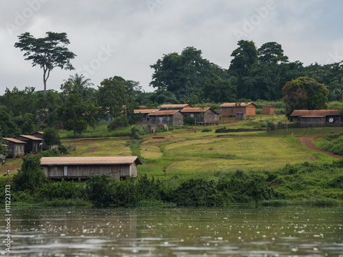 A small African village is situated on the green shores of the river Sangha (Nouabal-Ndoki National Park, Republic of the Congo)
