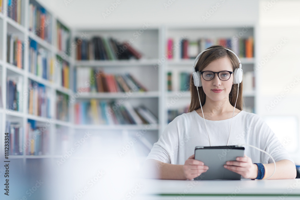 female student study in library, using tablet and searching for