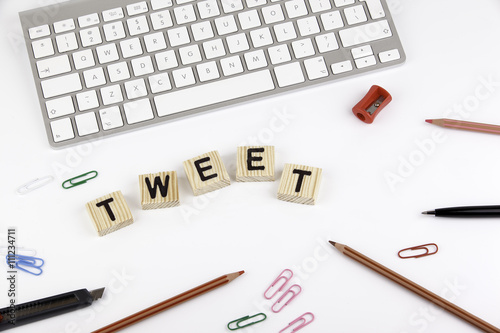 Text: TWEET from wooden letters on white office desk