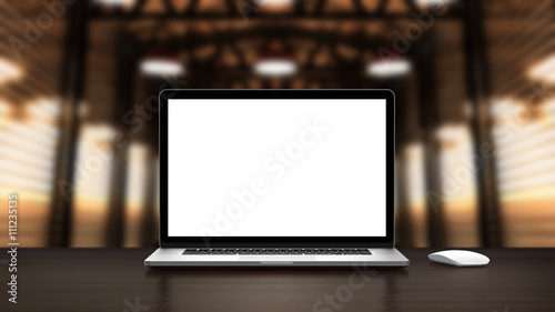 Laptop and mouse with blank screen in the interior vintage warehouse. Template, mockup.