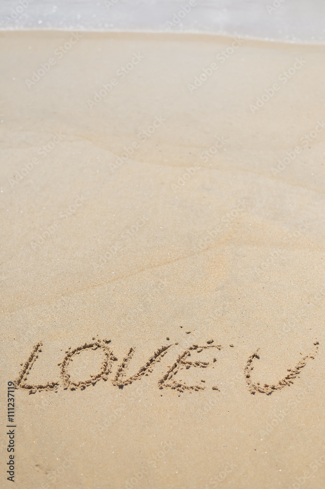 LOVE U sign on wet sand beach background 