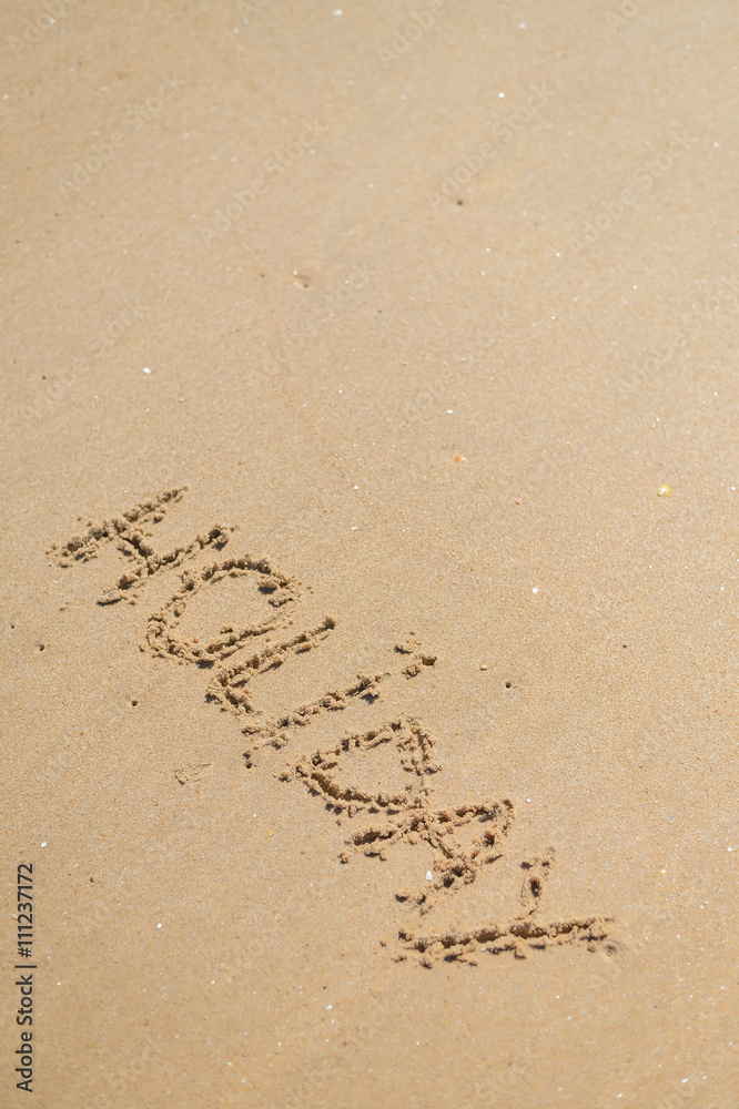 Fototapeta premium Top view on inscription Holiday on sea sand beach with the sun rays against wave foam. vacation concept