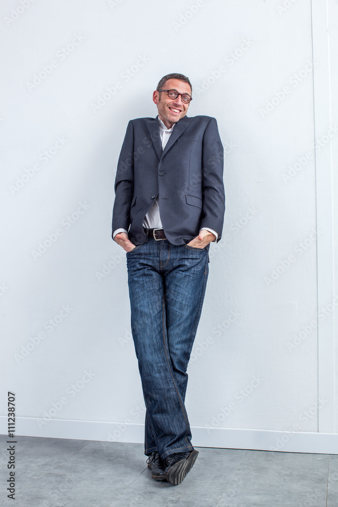 smiling modern entrepreneur shrugging and leaning on the office wall smiling modern entrepreneur shrugging and leaning on the office wall