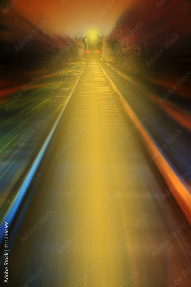 Nighttime shot of an electric train with light crossing