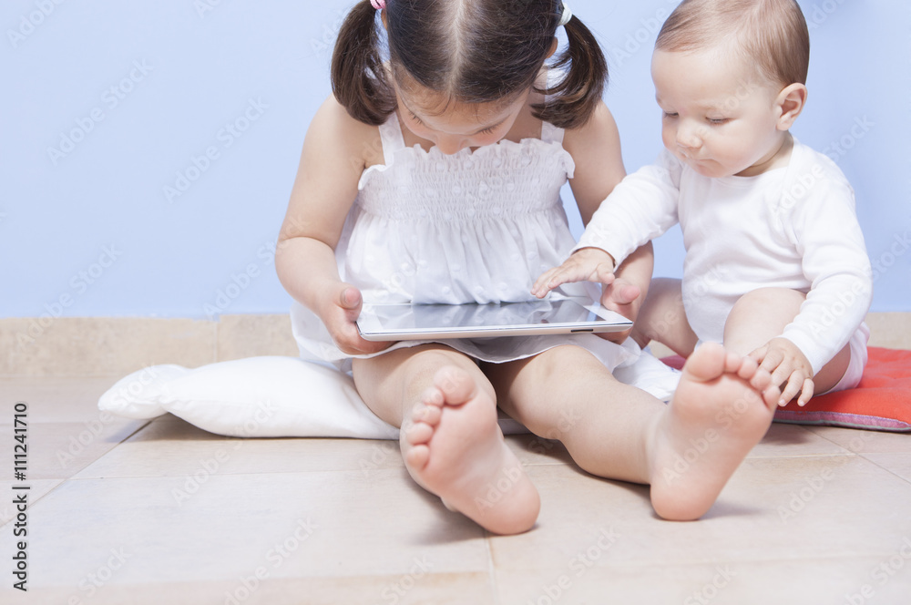 Baby boy discovering her sister tablet pc Baby boy discovering her sister tablet pc