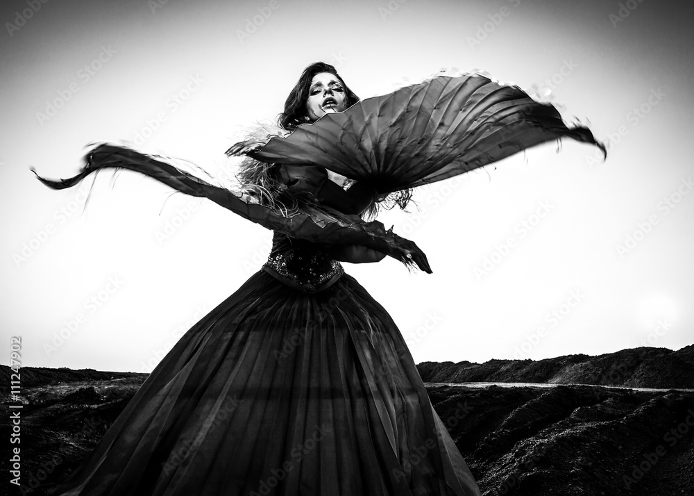Fototapeta premium Black-white fine art portrait of attractive romantic woman at fairy tale dry field.