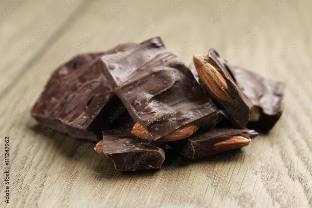 homemade chocolate with almond nuts on oak wood table, shallow focus homemade chocolate with almond nuts on oak wood table, shallow focus