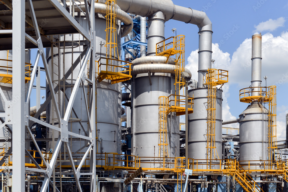 Industrial equipment and pipelines at the gas processing plant on a bright sunny summer day Industrial equipment and pipelines at the gas processing plant on a bright sunny summer day
