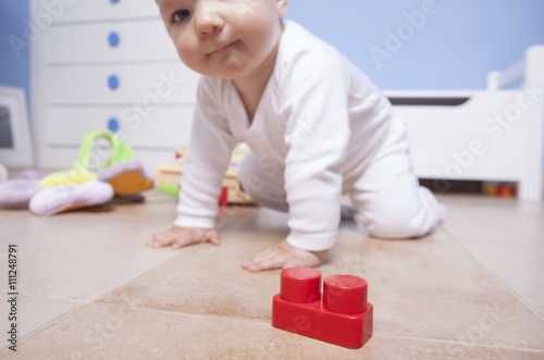 baby boy playing with plastic building blocks