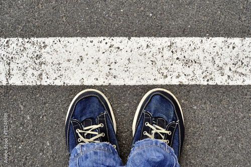 Top View of Male shoes on the asphalt road with white line, Step
