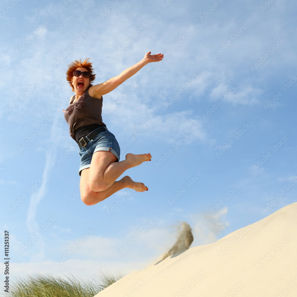 joy/ woman jumping for joy off a dune at the beach joy/ woman jumping for joy off a dune at the beach