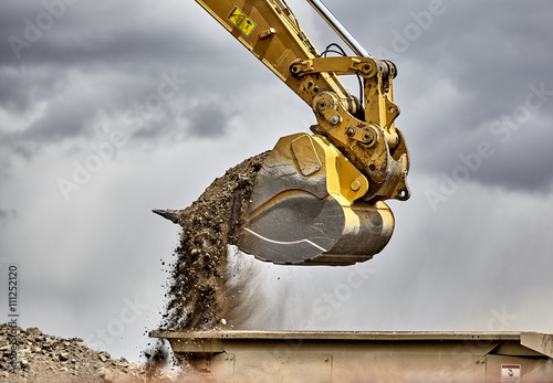 Construction industry excavator bucket loading gravel closeup