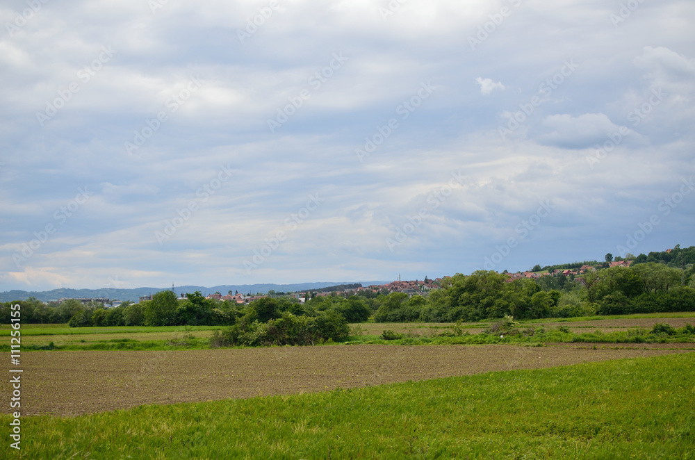 Plains and arable land under cloudy sky in spring