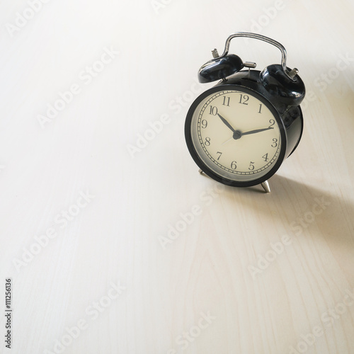 Vintage Retro black alarm clock on wooden background ( Composition and space foe text )