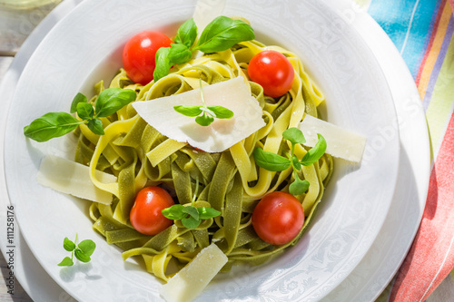 Closeup of homemade tagliatelle with basil and tomato