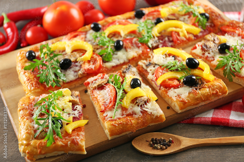 Pieces of delicious pizza on the table, close-up Pieces of delicious pizza on the table, close-up